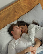 Couple sleeping in a bed with a wooden headboard, featuring text about the bed's features.